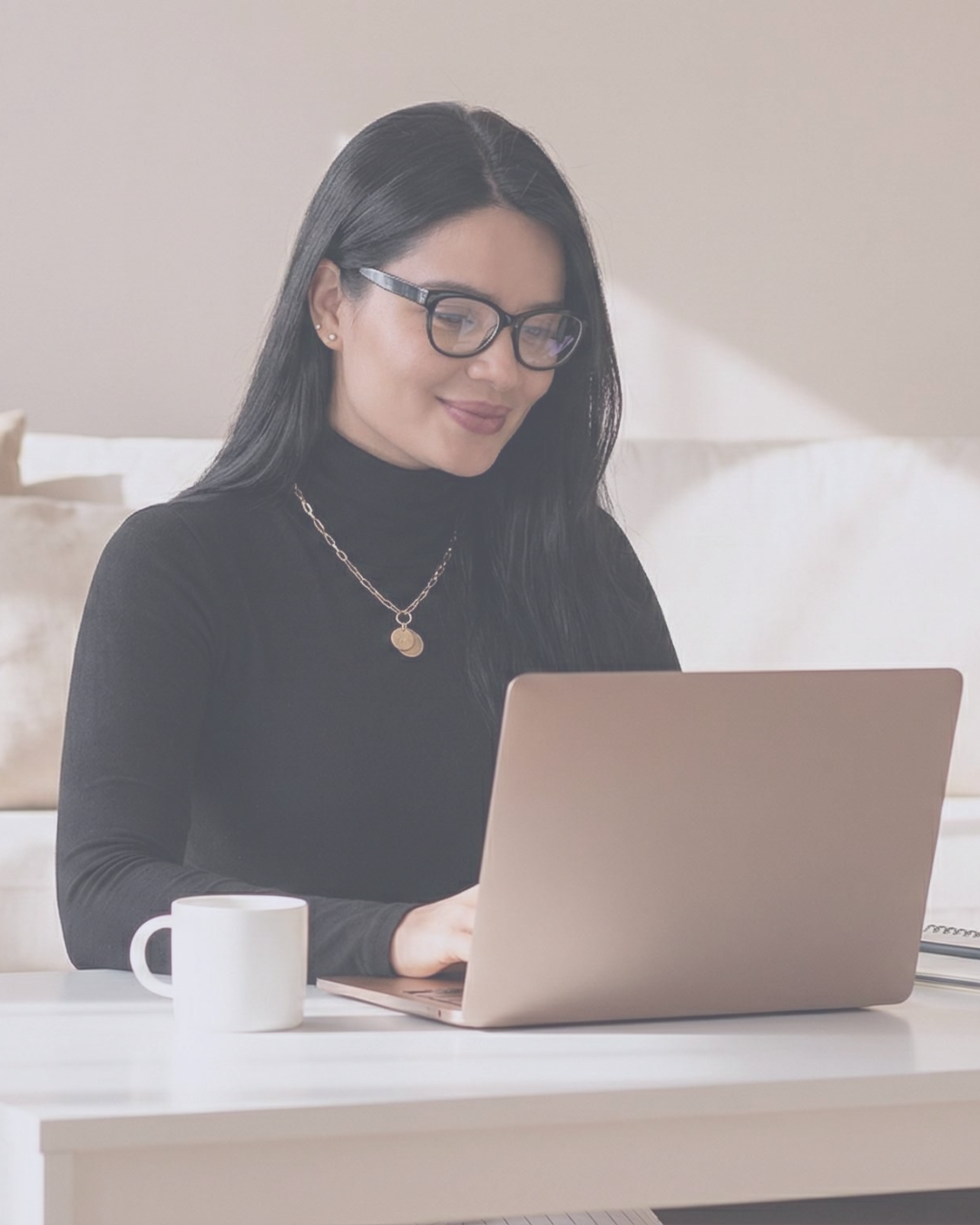 Mujer sonriendo frente a su computadora portátil durante una sesión de Terapia Transpersonal en Línea
